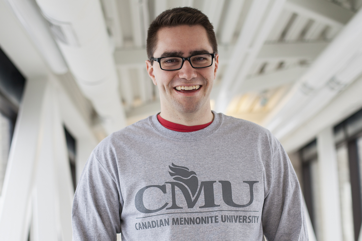 Jason Friesen - The courage to be vulnerable (Portrait of Jason Friesen on the Marpeck bridge wearing a grey long sleeved t-shirt with the CMU logo across the chest.)