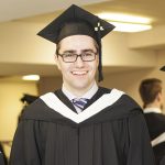Jason Friesen wearing his black graduation cap and gown on the day of his graduation from CMU's Communications and Media program.